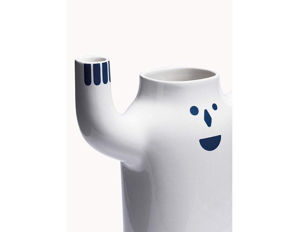 Glossy white ceramic vase with raised arms, decorated with deep blue facial features and fingertip accents. Its friendly expression and bold shape give it a playful and modern character.