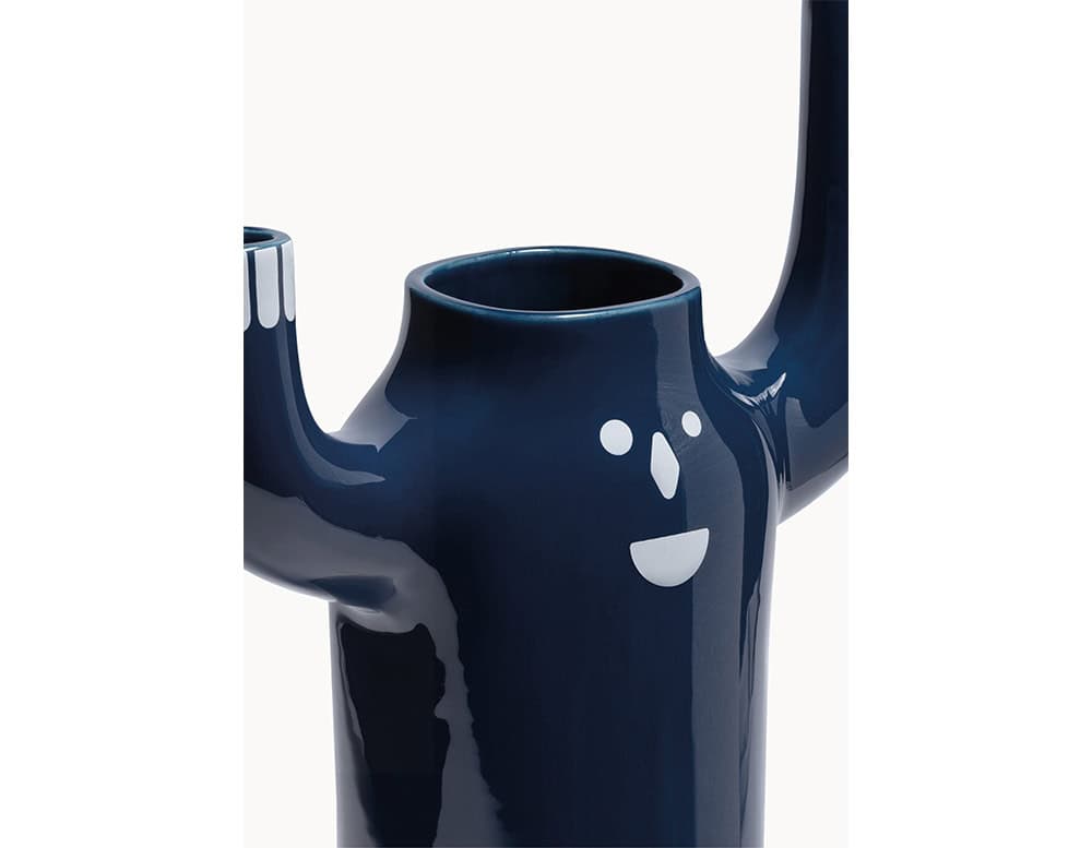 Glossy dark blue ceramic vase shaped like a cheerful figure with raised arms and a friendly face. Its smooth surface and bold color make it a playful yet elegant decorative piece.