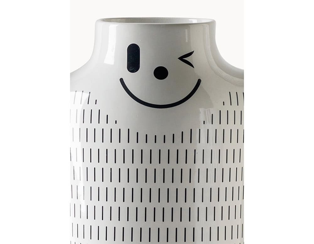 Glossy ceramic surface with a playful winking face, finished with a pattern of vertical black dashes. Expressive and full of character, perfect for adding charm to any setting.