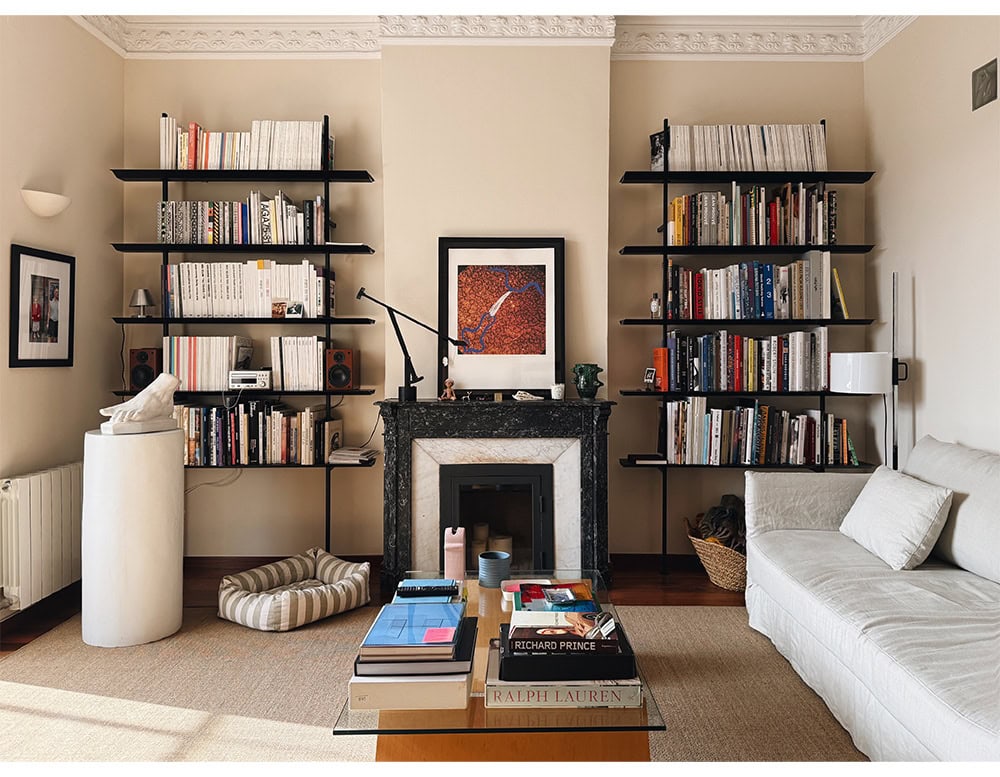 two hypostilo shelves in a living room, both shelves are full of books