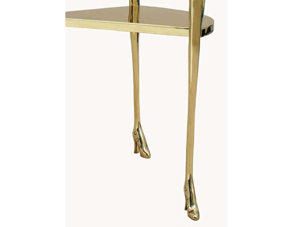The BD Leda Armchair features polished bronze legs, sculpted in the form of delicate limbs wearing buttoned heels. The surreal silhouette blends art and design into a playful yet refined statement.