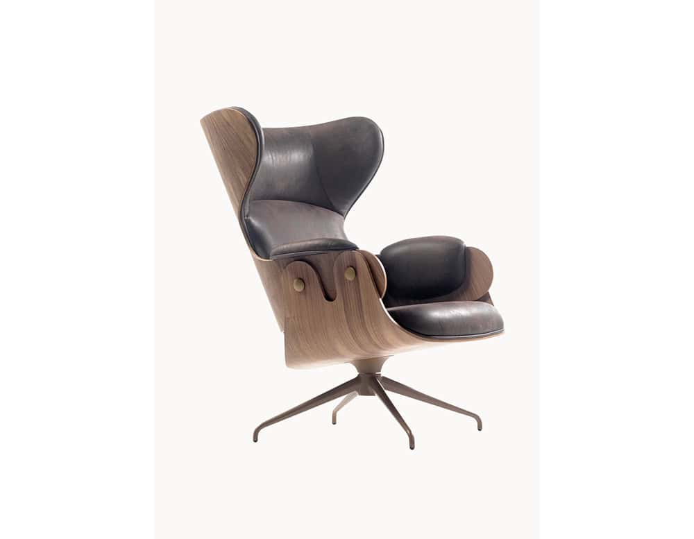 Lounger Armchair with a walnut wood shell and black leather upholstery. Its high back, sculpted form, and cushioned armrests offer luxurious comfort paired with refined, contemporary style.