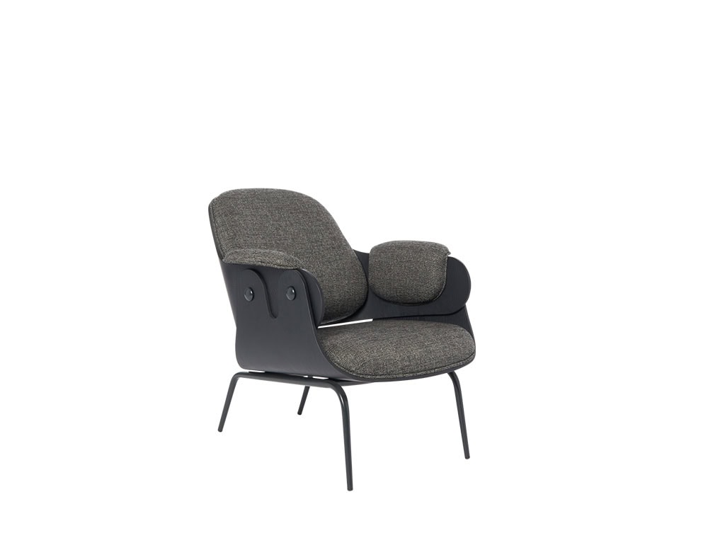 A sculptural armchair with soft, rounded cushions in textured grey fabric. The sleek black frame wraps around the sides, adding definition and structure to the relaxed silhouette.