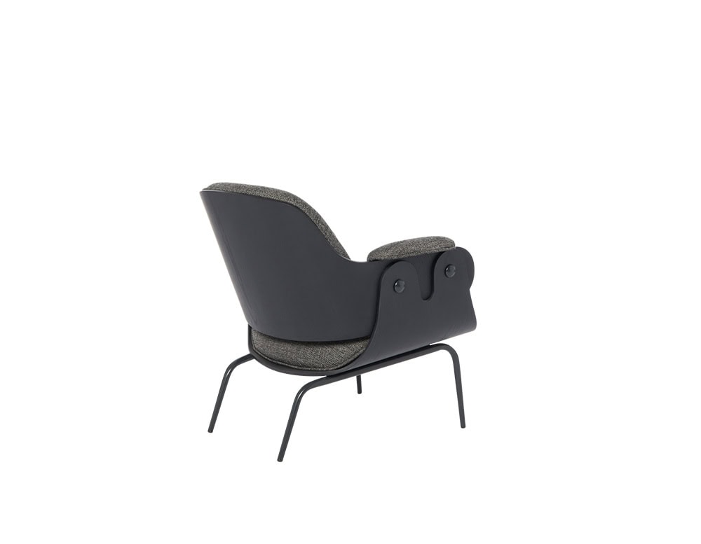 Low Lounger Armchair with angled black wood frame, slim legs, and tactile grey fabric. Sculpted arm panels and generous cushions offer comfort with a bold, playful silhouette. A balance of softness and structural clarity.