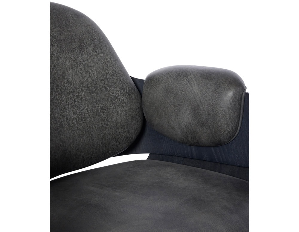 Low Lounger Armchair in close-up. Highlights include rich, textured dark gray leather, ergonomic backrest, and plush side cushion for extra comfort. A modern design accentuating detail and material quality.