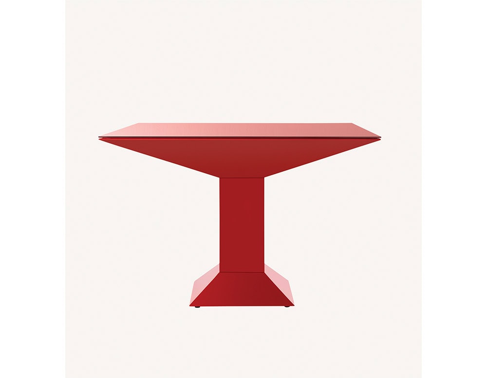 Mettsass Table in bold red lacquer with angular pedestal base and beveled square top, shown in a striking sculptural profile.