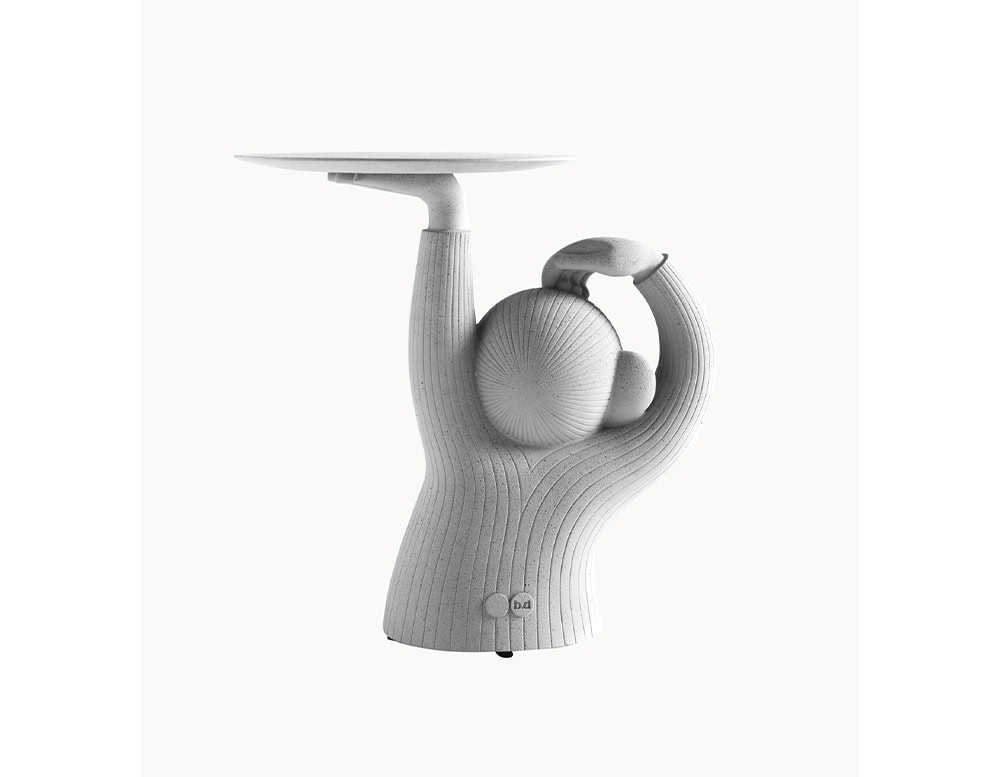 A view of the BD Monkey Side Table highlights the sculptural silhouette with its raised arm supporting the tabletop. The textured concrete surface emphasizes the playful yet functional design, bringing character to the piece.