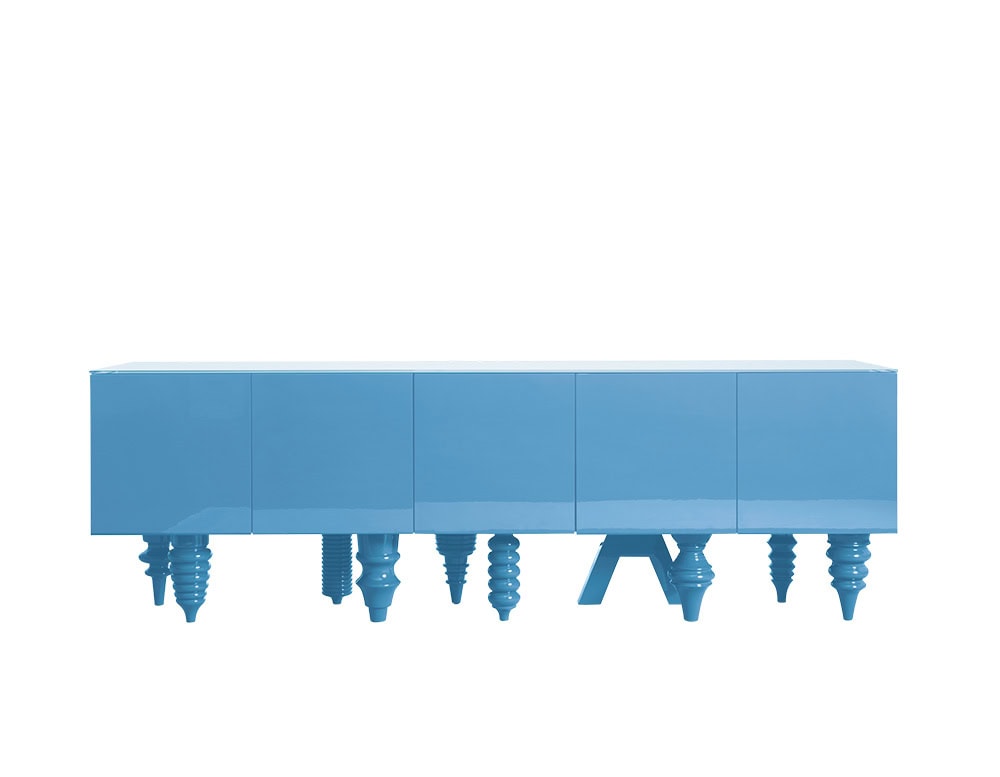 A vibrant blue cabinet finished in a sleek, polished coating. The surface is clean and minimal, while the base features a playful mix of sculptural legs in assorted forms and dimensions. The design balances simplicity with decorative character.
