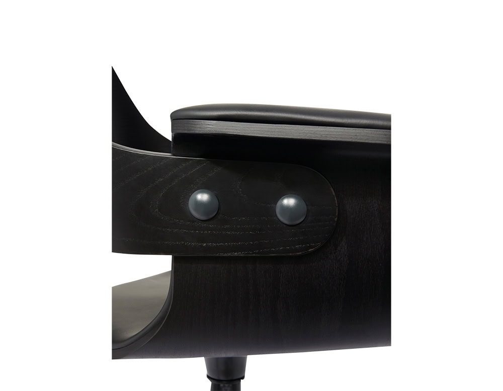 The armrest features a sculpted matte black wood shell with two rounded metal fasteners, topped by a softly upholstered cushion that contrasts with the bold curvature and precise joinery.