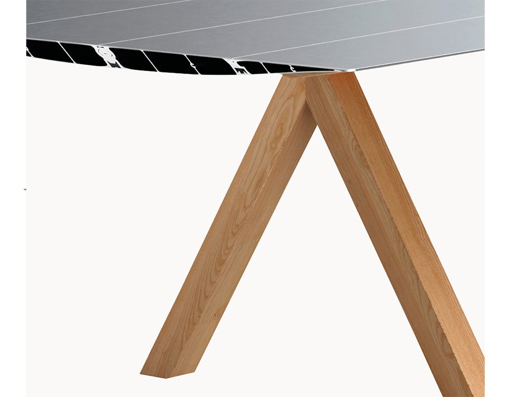 The BD Table B pairs its precision-milled aluminum tabletop with warm, natural wooden legs. The angled supports add a sculptural and functional element to the design.