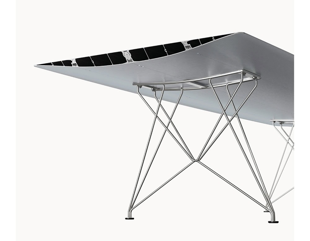The BD Table B is supported by a stainless steel leg structure, showcasing a geometric crisscross design. Its sleek metallic base complements the aerodynamic tabletop, blending stability with minimalist elegance.