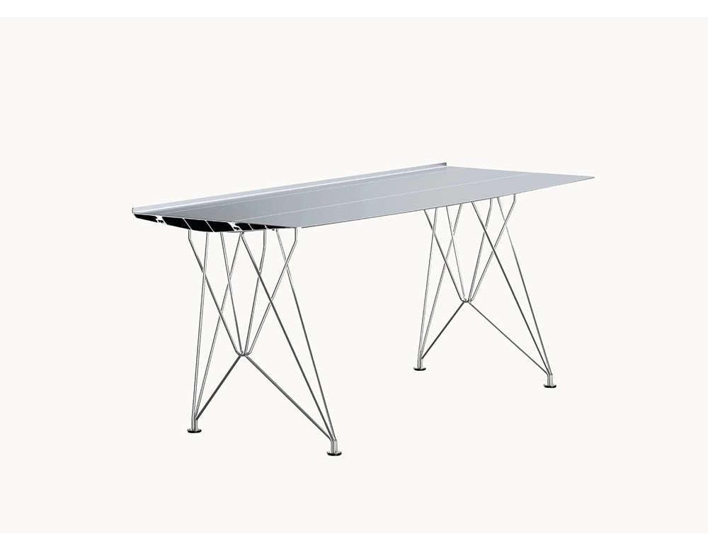 The BD Table B pairs a sleek aluminum tabletop with a stainless steel rod base, creating a lightweight yet structurally bold appearance. The metallic tones emphasize the table’s contemporary industrial aesthetic.