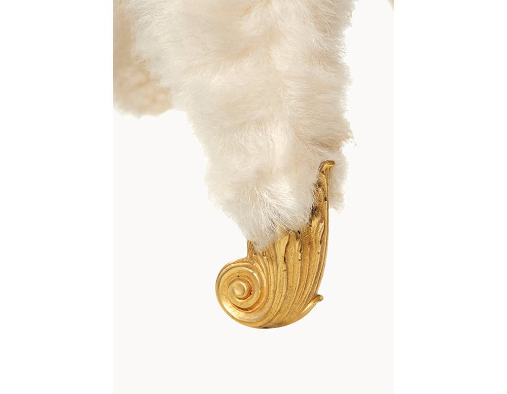 A close-up view of one of the feet reveals a golden, ornamental hoof detail with a curled motif, adding a whimsical and luxurious touch to the overall design.