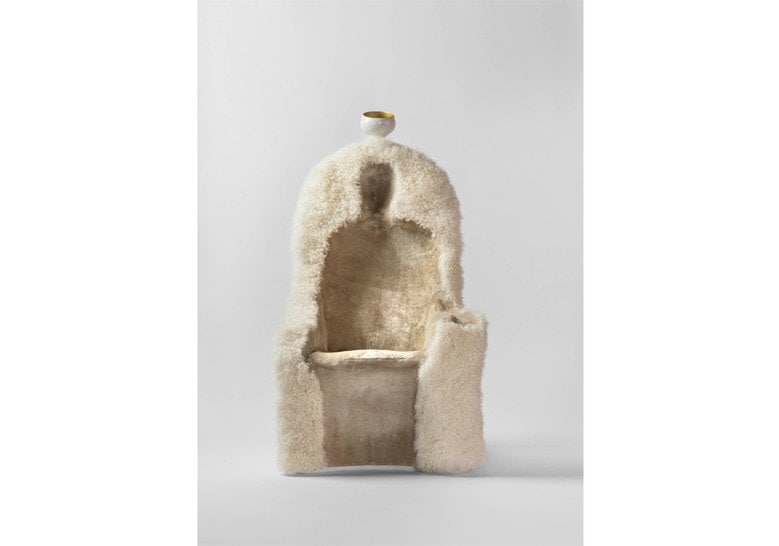 armchair made of sheepskin in the shape of a human silhouette in a white tone on a white background