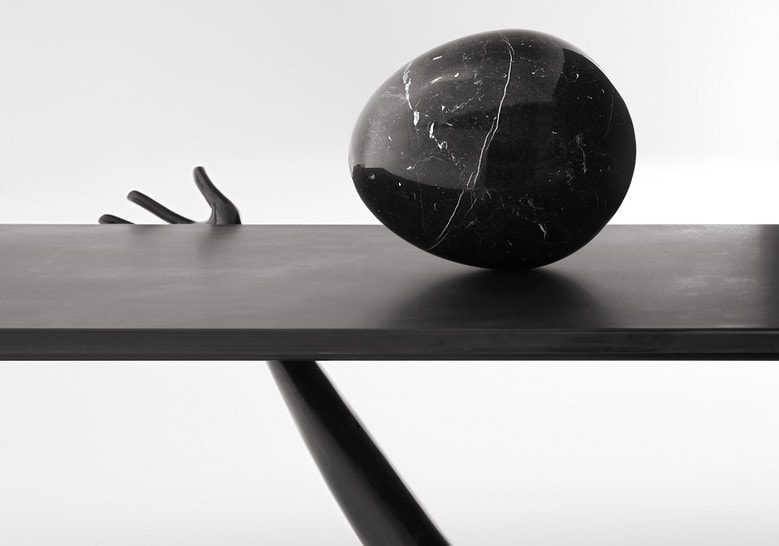 table made in the form of human arms on a marble base in a black tone