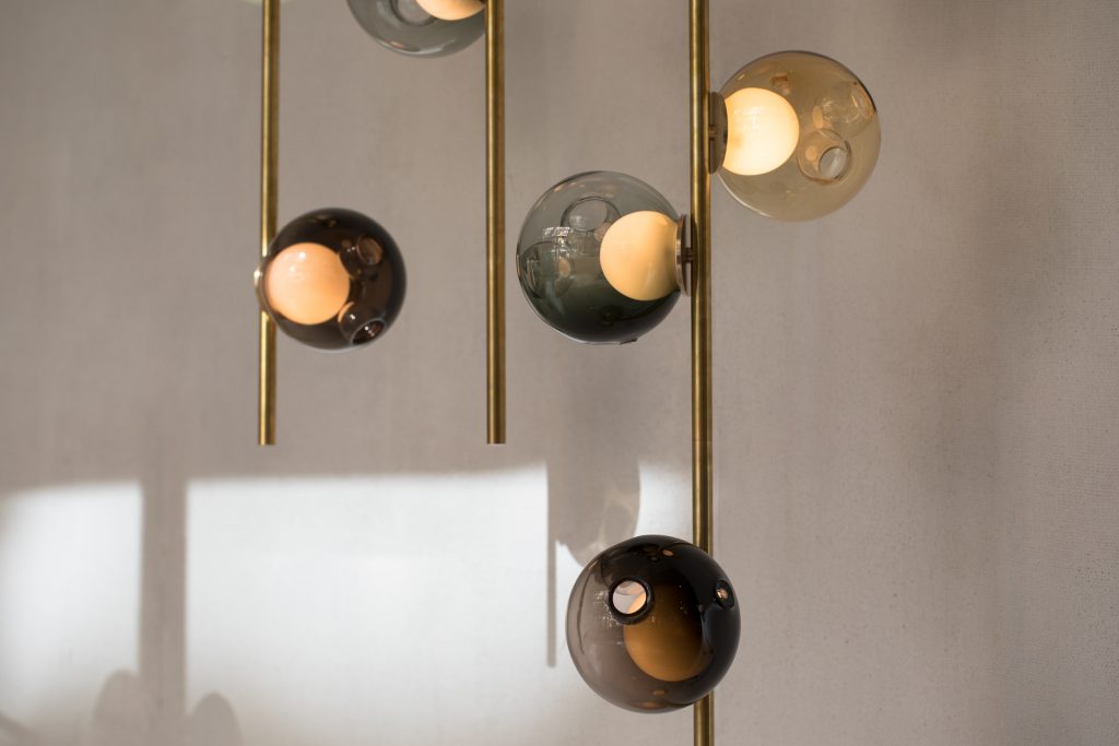 line of lamps made of golden steel and lamp domes made of a thin black cover