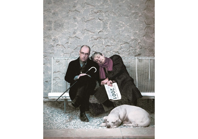 stainless steel bench in a gray color tone with two people in the background