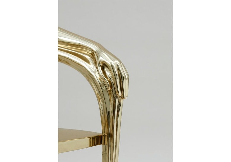 chair made in the shape of heels on its base and made of brass in a golden tone