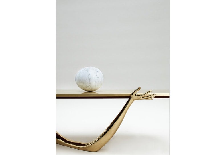 sculpture made in the form of human arms on a marble base in a golden tone and white finishes