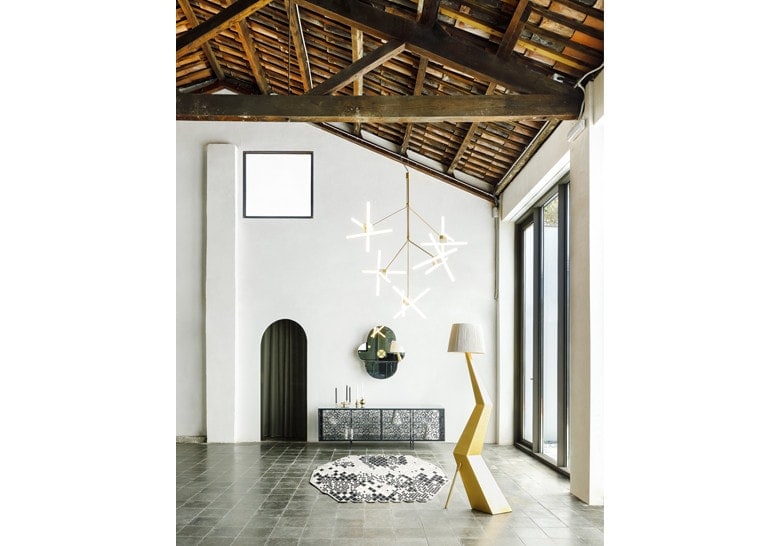 lamp made in the shape of a snowflake on a steel base in a golden tone on a living room