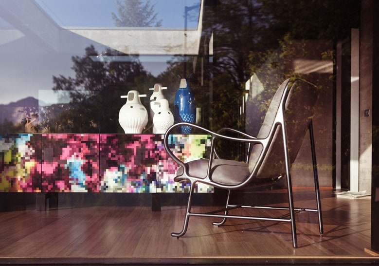 two small sculptures of different sizes in a tone of white on a piece of furniture in a living room