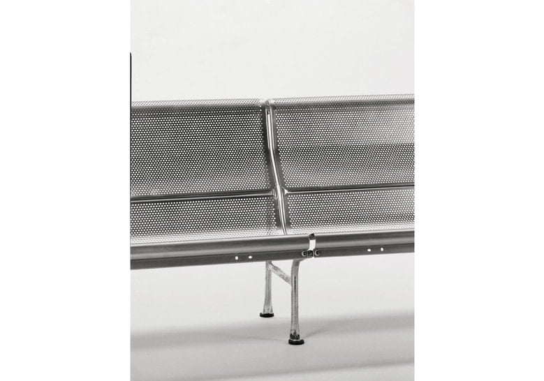 stainless steel bench in a gray color tone with two people in the background