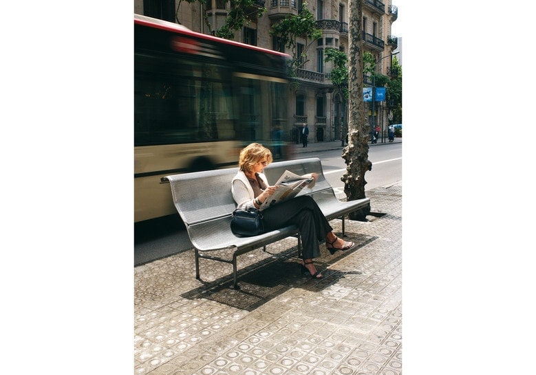 steel bench in all its structure in a gray color tone with a person dwe background