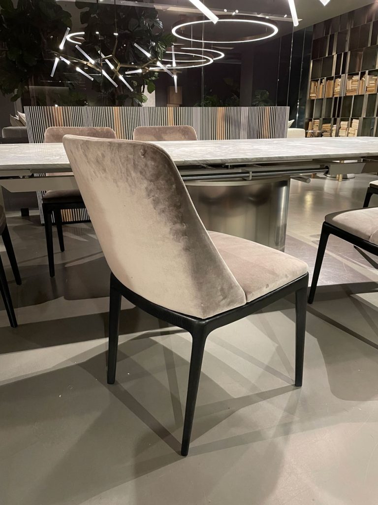 dining room chairs made of velvet in a gray tone and black wooden legs