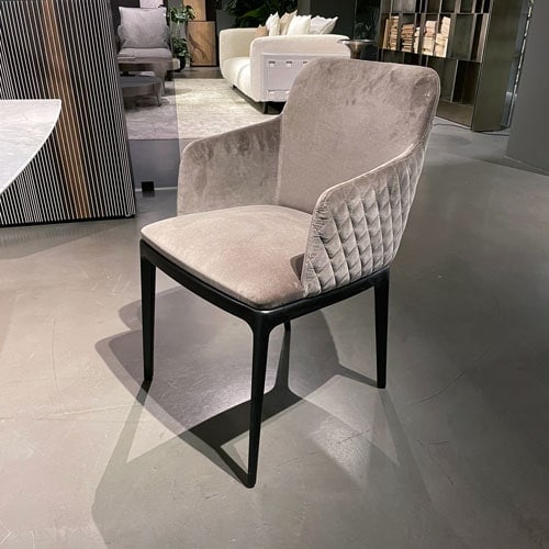 Dining chair made with a wooden base and upholstered in velvet with spike-shaped finishes in a light gray tone