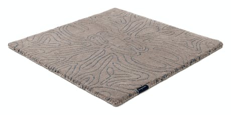 rug made of velvet and hand-braided in a beige tone with lines drawn in its design