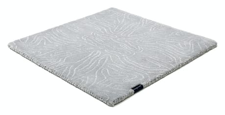 rug made of velvet and hand-braided in a blue tone with lines drawn in its design