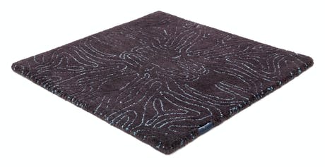 rug made of velvet and hand-braided in a brown tone with lines drawn in its design