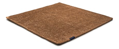 Handmade rug made of fine wool and fabrics in a brown tone on a white background