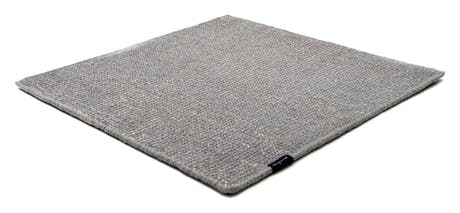 Handmade rug made of fine wool and fabrics in a ligth gray tone on a white background