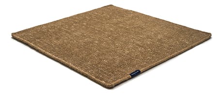 Handmade rug made of fine wool and fabrics in a ligth brown tone on a white background