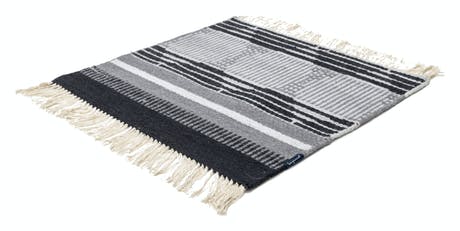 hand-woven rug with fabric in shades of blue black and beige