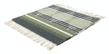 hand-woven rug with fabric in shades of green and beige