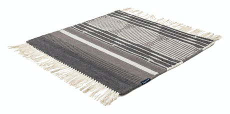 hand-woven rug with fabric in shades of gray white and beige
