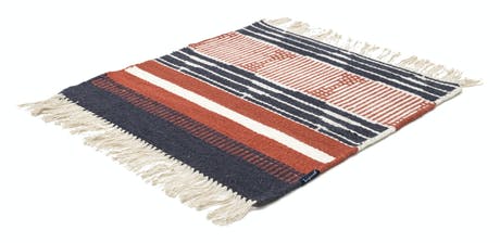 hand-woven rug with fabric in shades of red blue and beige