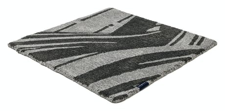 rug made of fabric and handwoven in a zebra design in a dark gray and black color tone