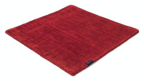braided and hand-woven rug in wool and velvet in a ruby ​​red color tone