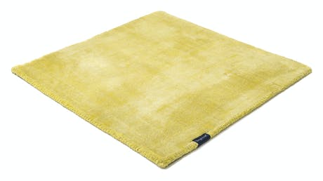 handmade rug in a light yellow tone with white finishes on a white background