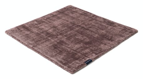 handmade rug in a red tone with white finishes on a white background