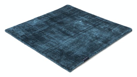 handmade rug in a dark blue tone with white finishes on a white background