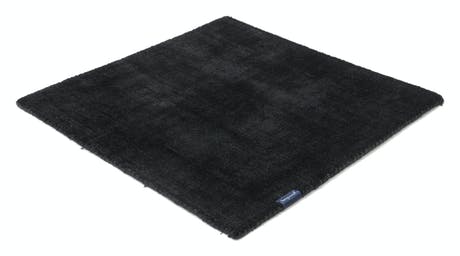 handmade rug in a black tone with white finishes on a white background