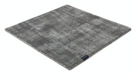 handmade rug in a dark gray tone with white finishes on a white background
