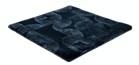 Handmade velvet rug in shades of black with patch finishes of the same light color