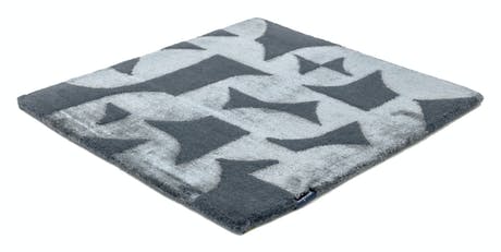 Handmade velvet rug in shades of gray with patch finishes of the same light color