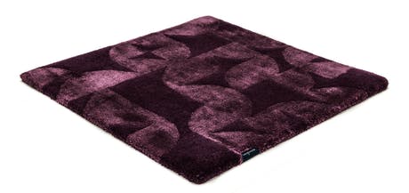 Handmade velvet rug in shades of red with patch finishes of the same light color