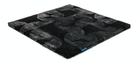 Handmade velvet rug in shades of black with patch finishes of the same light color